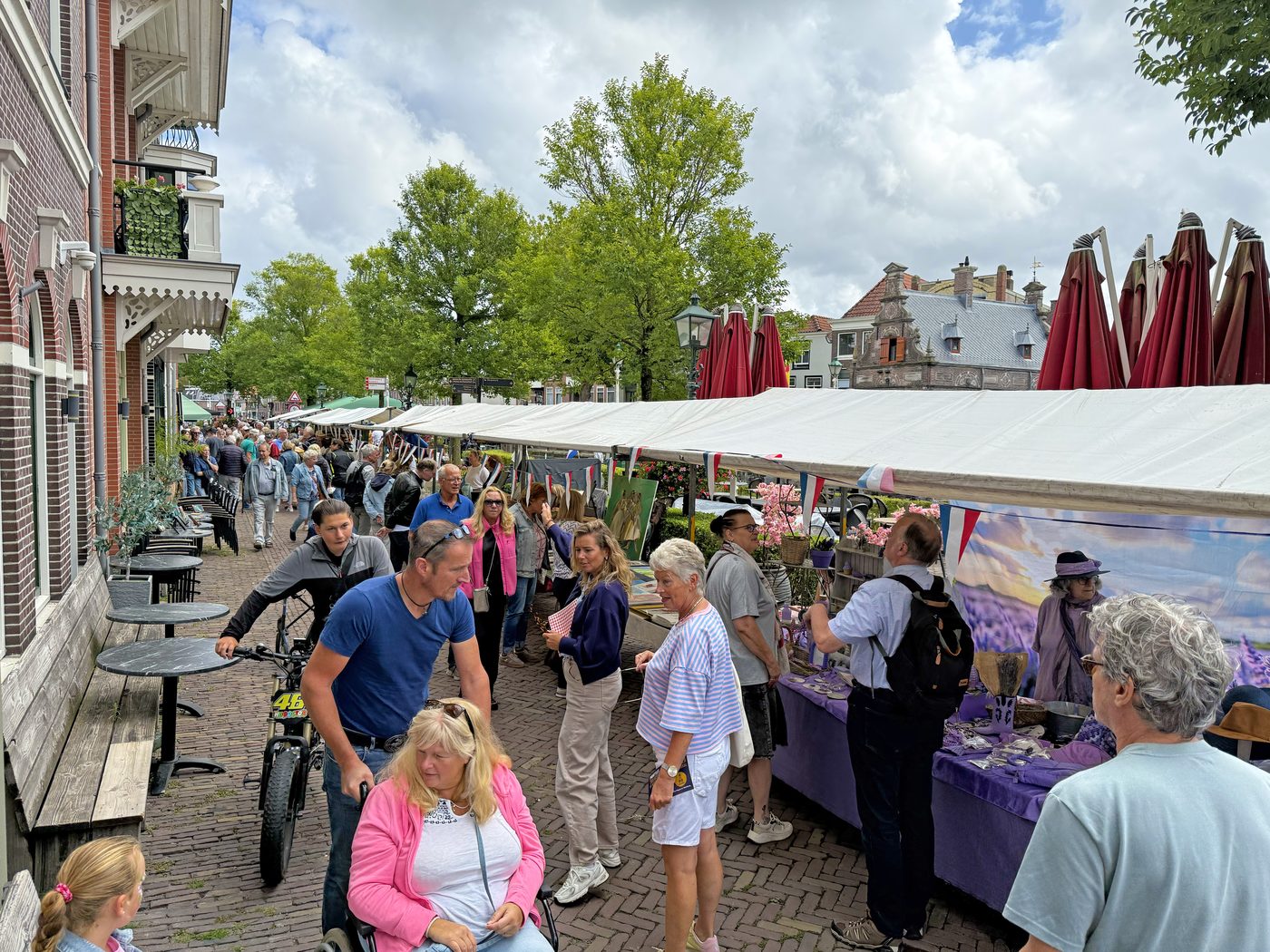 Gezinnen en bezoekers wandelen langs de kramen op de Damlaan
