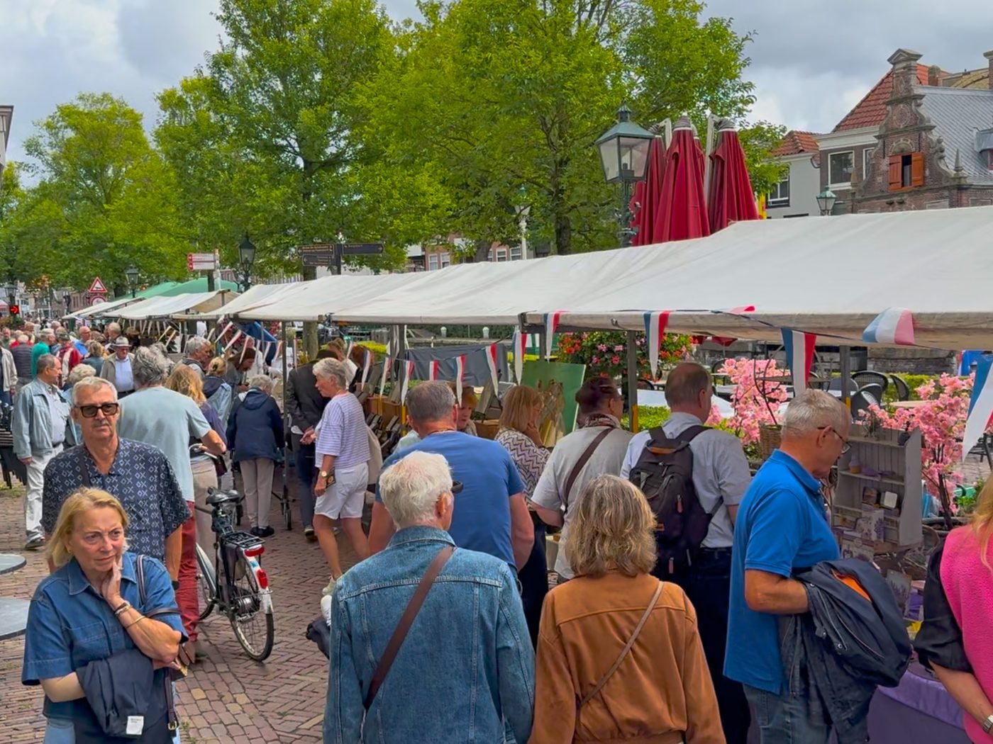 Druk publiek struint langs de kramen onder de witte marktkappen aan de sluis